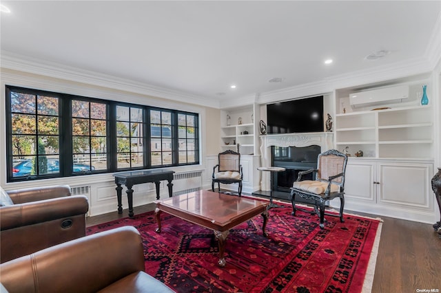 living room with hardwood / wood-style flooring, built in features, crown molding, and a wall mounted AC