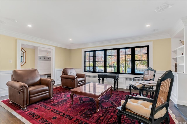 living room with built in shelves, wood-type flooring, radiator, and crown molding