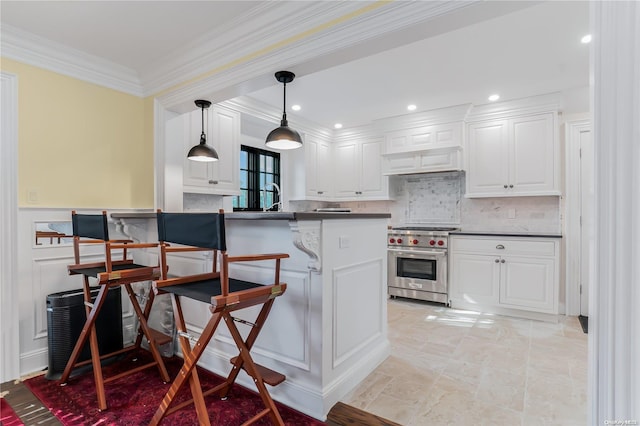 kitchen with luxury range, a kitchen breakfast bar, kitchen peninsula, pendant lighting, and white cabinets