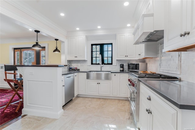 kitchen featuring kitchen peninsula, stainless steel appliances, sink, decorative light fixtures, and white cabinets