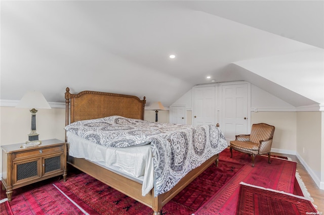 bedroom with hardwood / wood-style flooring and lofted ceiling