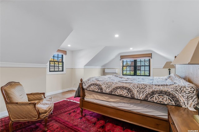 bedroom with light hardwood / wood-style floors, multiple windows, and lofted ceiling