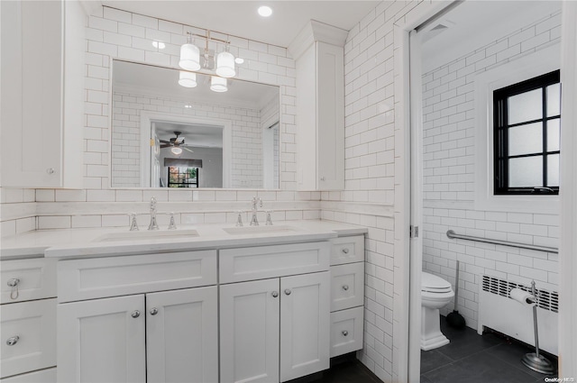 bathroom with ceiling fan, radiator heating unit, tile patterned floors, toilet, and tile walls