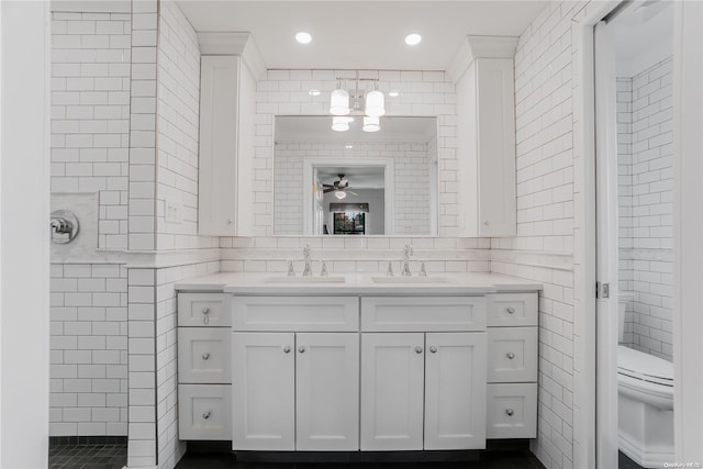 bathroom with ceiling fan, vanity, tile walls, and toilet