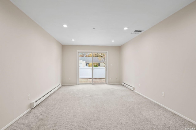 carpeted spare room with a baseboard heating unit