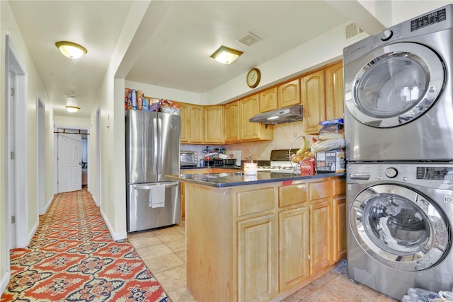 kitchen featuring a barn door, stainless steel fridge, light brown cabinetry, light tile patterned floors, and stacked washer and clothes dryer