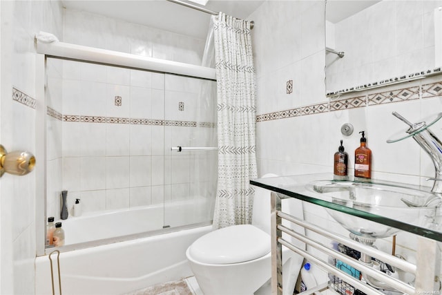 full bathroom featuring toilet, sink, tile walls, and shower / tub combo with curtain