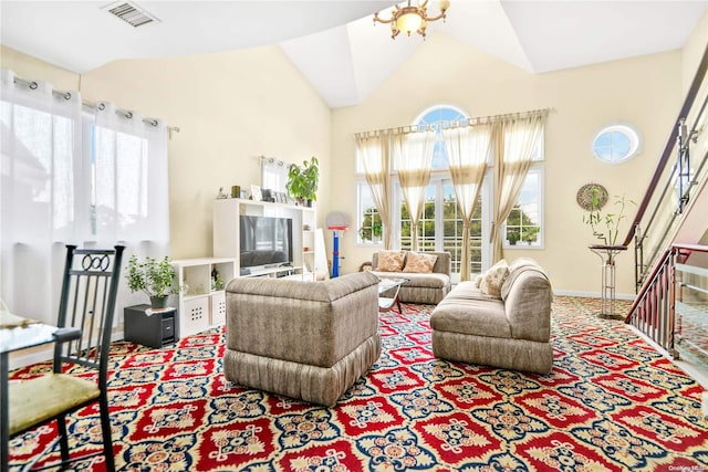 carpeted living room with a notable chandelier, a healthy amount of sunlight, and vaulted ceiling