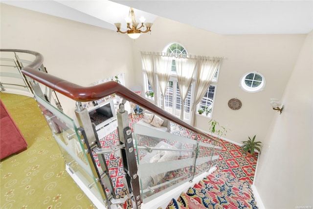 stairs featuring carpet flooring, lofted ceiling, and a notable chandelier