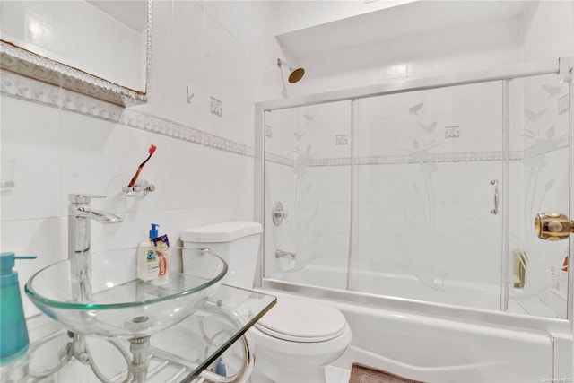 full bathroom featuring sink, toilet, tile walls, and enclosed tub / shower combo