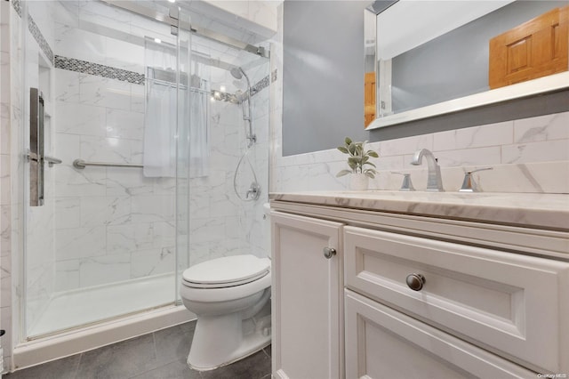 bathroom featuring vanity, backsplash, tile patterned flooring, toilet, and an enclosed shower