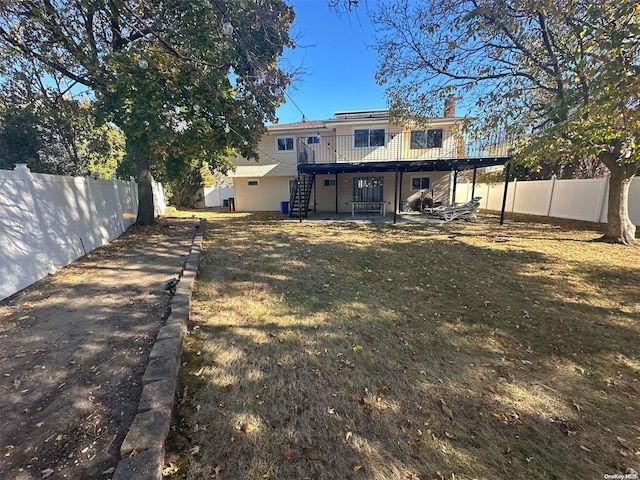 rear view of property with a lawn and a deck