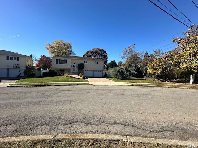 split foyer home with a garage and a front lawn