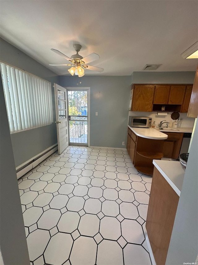 kitchen featuring ceiling fan, a baseboard heating unit, and sink