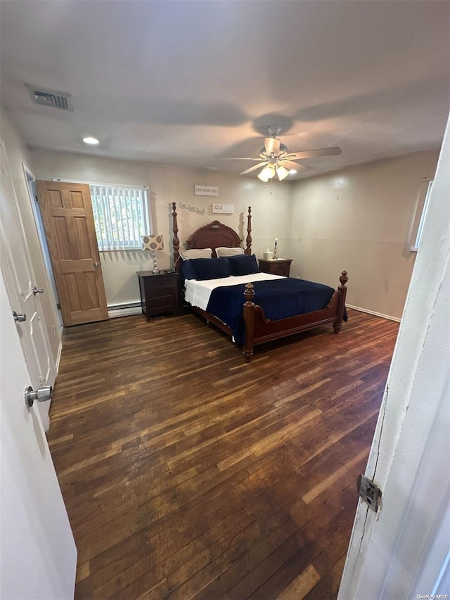 bedroom featuring ceiling fan, dark hardwood / wood-style flooring, and baseboard heating