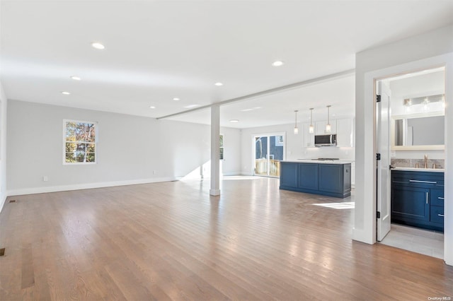 unfurnished living room with sink and light hardwood / wood-style floors