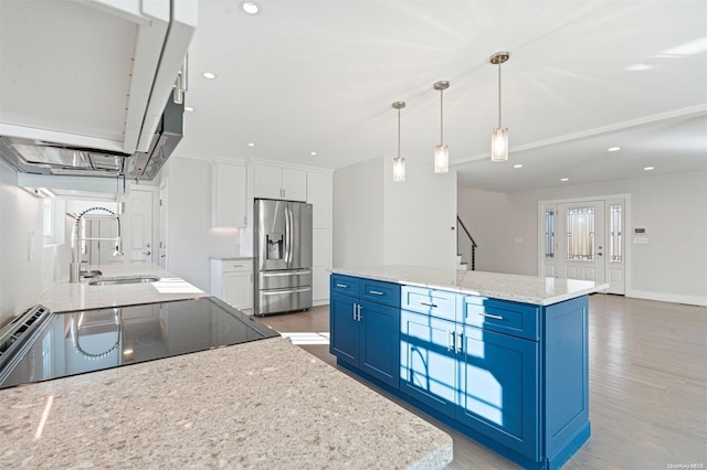 kitchen featuring hardwood / wood-style floors, white cabinets, blue cabinets, a kitchen island, and stainless steel fridge with ice dispenser