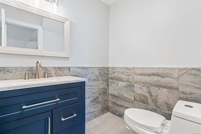 bathroom with tile patterned flooring, toilet, and tile walls