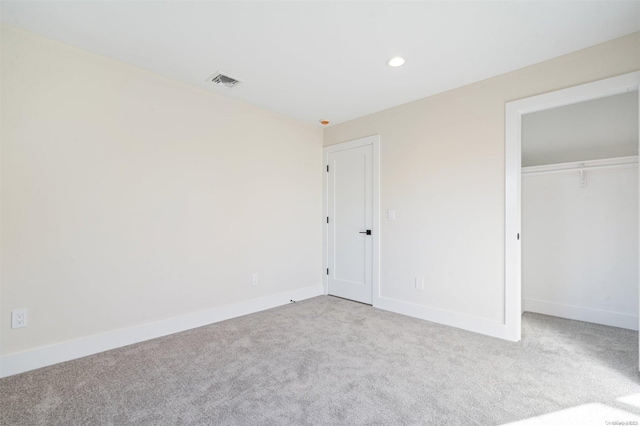 unfurnished bedroom with light carpet and a closet