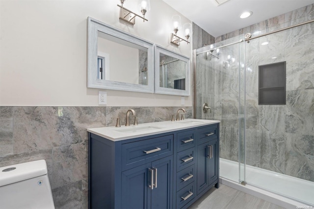 bathroom with vanity, toilet, tile walls, and walk in shower