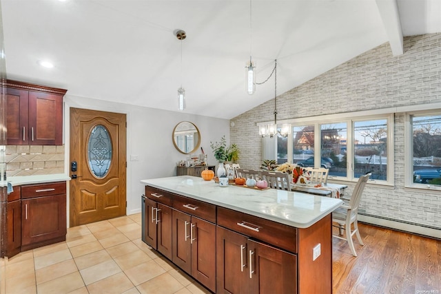 kitchen featuring pendant lighting, an inviting chandelier, vaulted ceiling with beams, light wood-type flooring, and a kitchen island