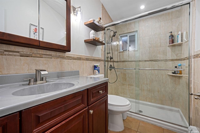 bathroom featuring vanity, tile patterned flooring, toilet, tile walls, and walk in shower