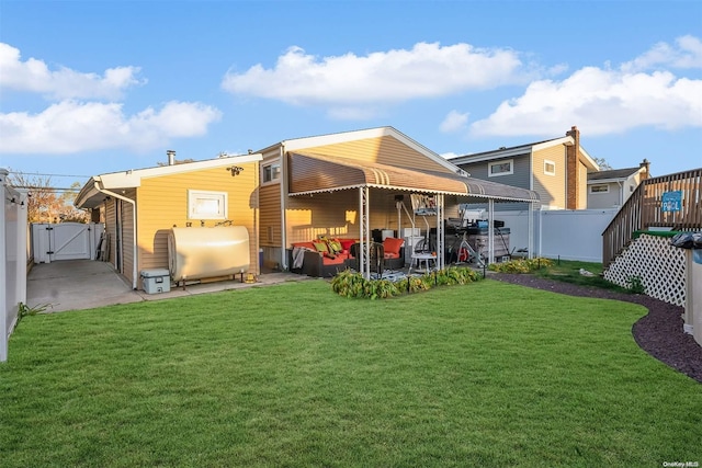 back of house with a lawn and a patio