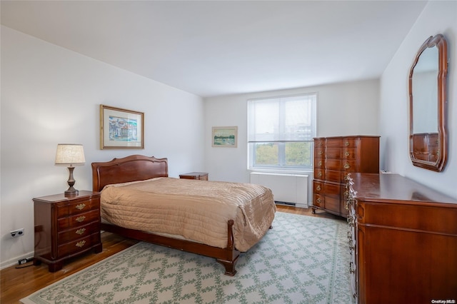 23-20 Bell Blvd Unit 5F, Bayside, NY 11360 - bedroom featuring radiator and wood finished floors