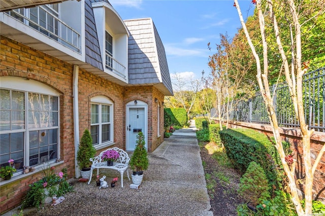 655 Middle Country Rd Unit 8D2, Coram, NY 11727 - view of property exterior featuring a balcony, brick siding, and mansard roof