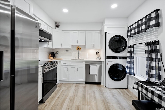 655 Middle Country Rd Unit 8D2, Coram, NY 11727 - kitchen featuring stainless steel appliances, stacked washer / drying machine, light countertops, white cabinetry, and recessed lighting