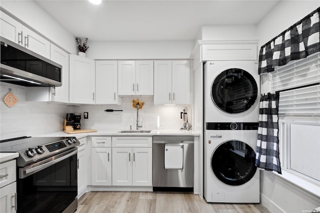 655 Middle Country Rd Unit 8D2, Coram, NY 11727 - kitchen with stainless steel appliances, stacked washer and clothes dryer, light countertops, and light wood-type flooring