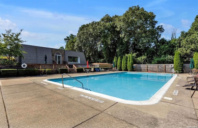 view of swimming pool featuring a patio and a deck