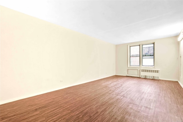 spare room with radiator and hardwood / wood-style floors