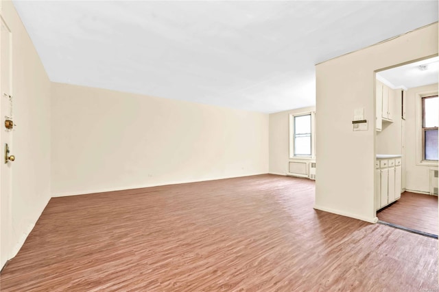 unfurnished living room featuring light hardwood / wood-style floors and radiator