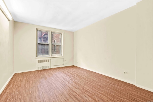 spare room featuring hardwood / wood-style flooring and radiator