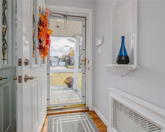 entryway with hardwood / wood-style floors and radiator heating unit