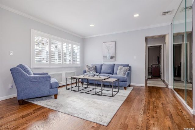 living room with hardwood / wood-style flooring and crown molding