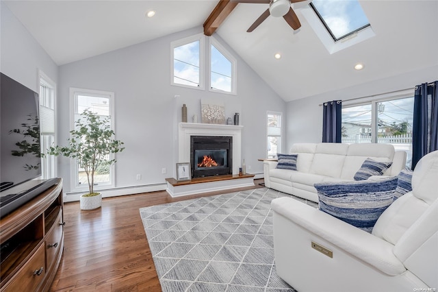 living room featuring hardwood / wood-style floors, a baseboard radiator, high vaulted ceiling, and plenty of natural light