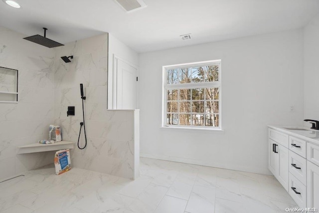 bathroom with vanity and a tile shower