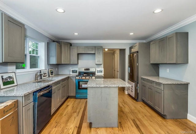 kitchen with gray cabinetry, sink, stainless steel appliances, and a kitchen island