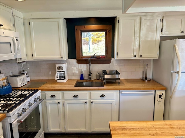 kitchen featuring tasteful backsplash, white cabinetry, sink, and white appliances