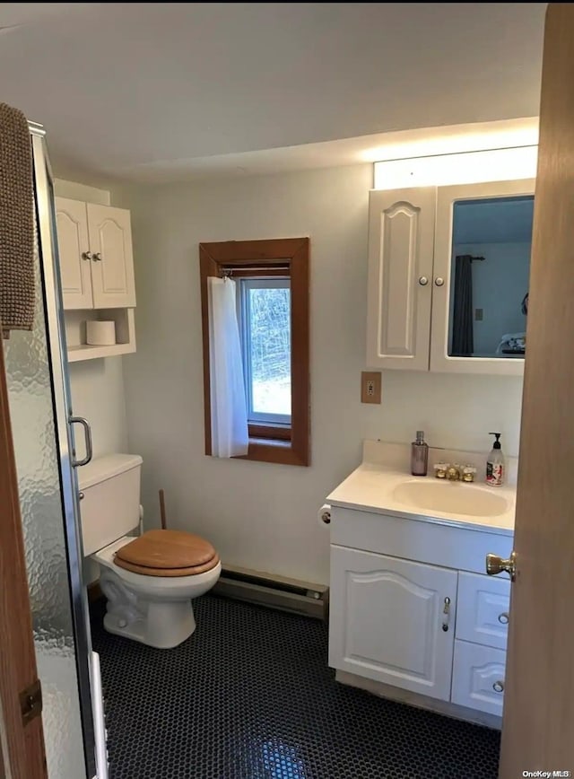 bathroom with toilet, vanity, and a baseboard heating unit