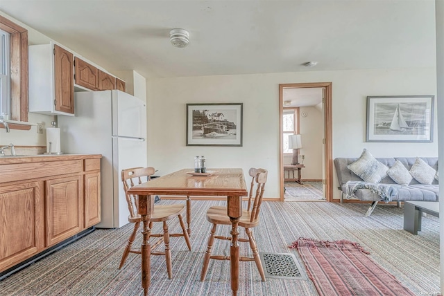 carpeted dining space with sink