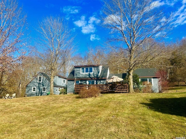 back of property featuring a deck and a yard