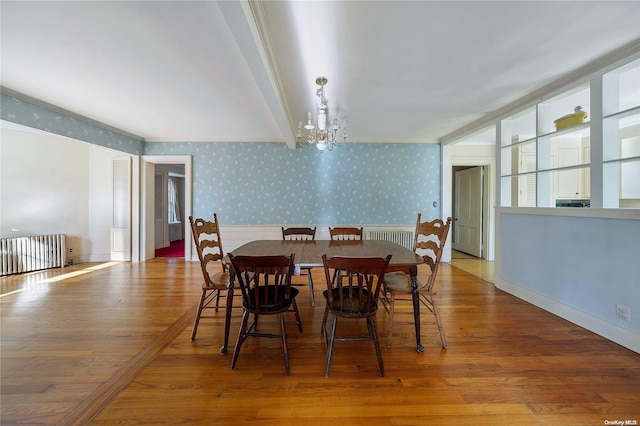 dining room with a chandelier, hardwood / wood-style flooring, radiator, and crown molding