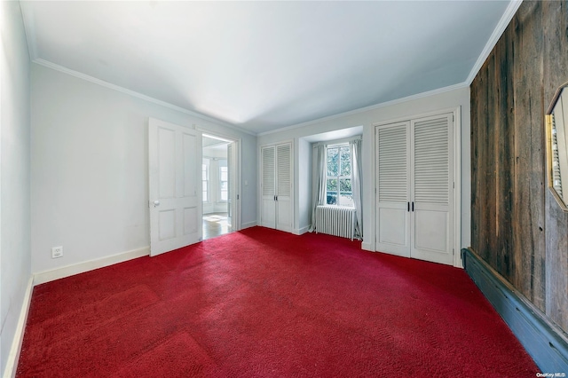 unfurnished bedroom featuring carpet, radiator heating unit, ornamental molding, and wooden walls