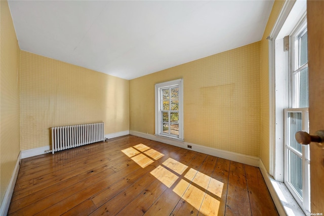 spare room featuring hardwood / wood-style flooring and radiator