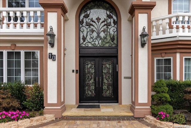 doorway to property featuring a balcony and french doors