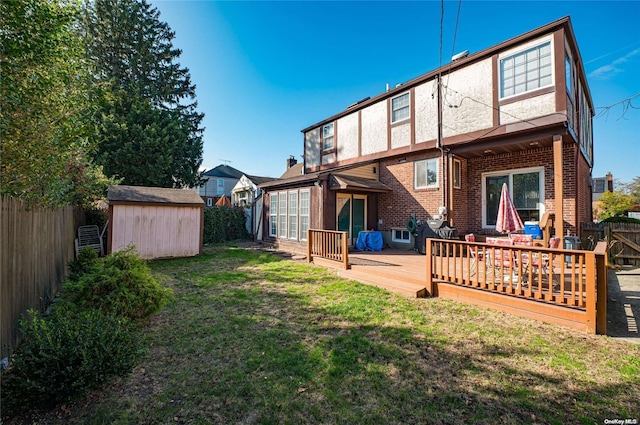 back of property with a lawn, a shed, and a wooden deck