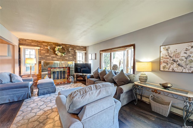 living room with a baseboard heating unit, dark wood-type flooring, and a brick fireplace